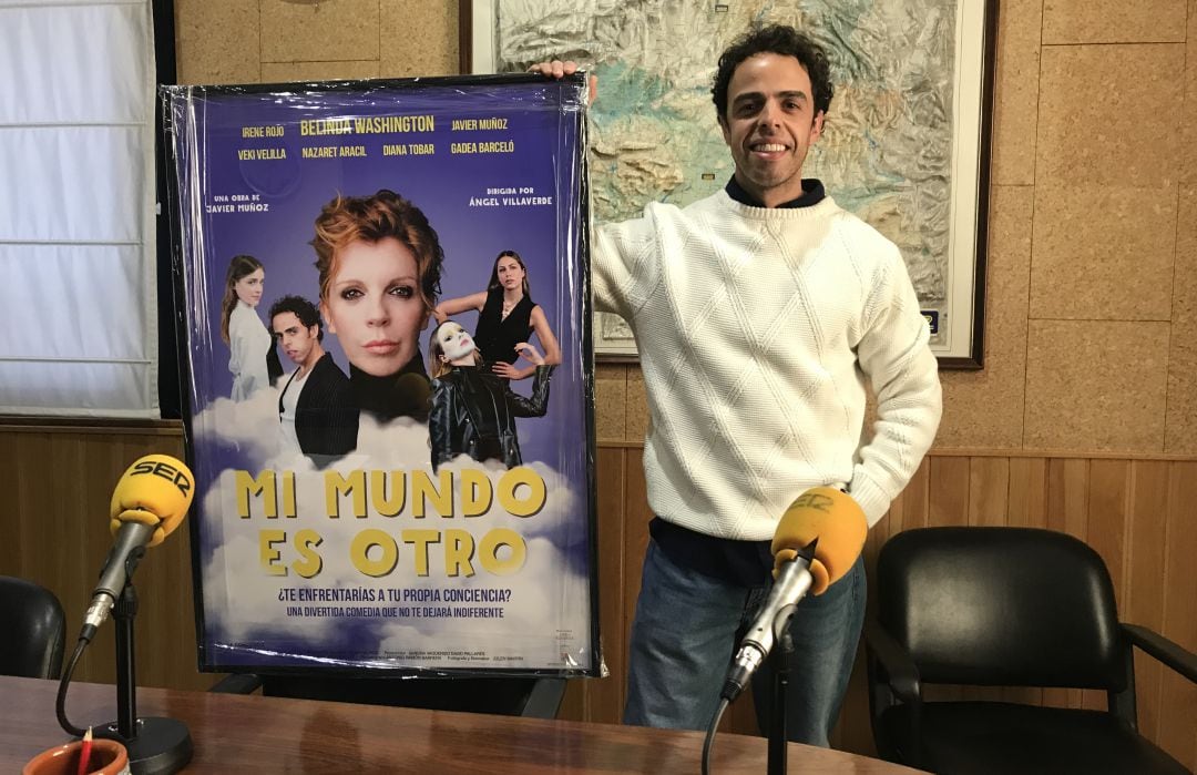 Javier Muñoz en los estudios de SER Cuenca con el cartel de la obra de teatro.