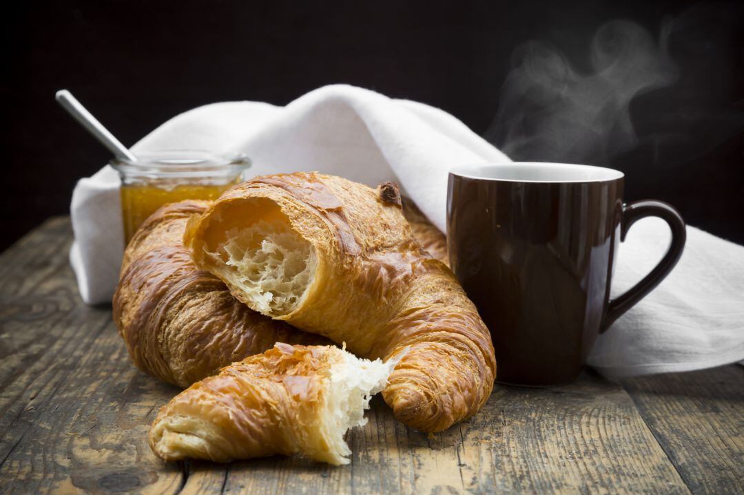 Un par de cruasanes junto a una taza de café