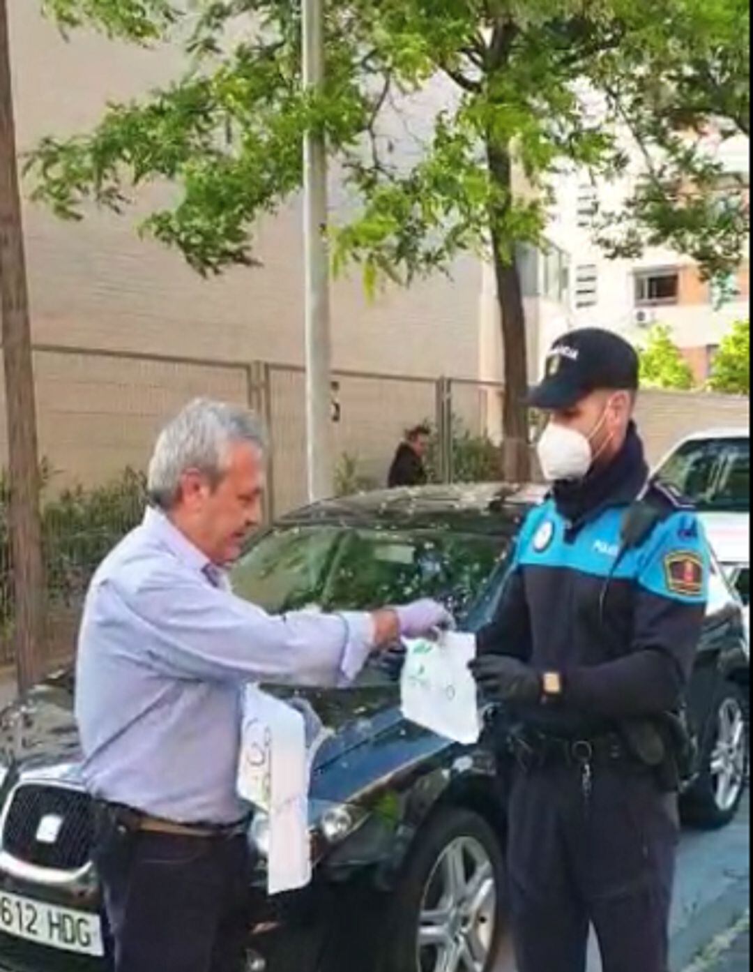 Fernando recogiendo dibujos que le han hecho los niños de la calle Sauces de Alcorcón
