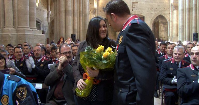 Un mosso lliura un ram de flors a la dona atropellada per un vehicle que fugia d'un control policial. Imatge del 15 d'abril de 2016.