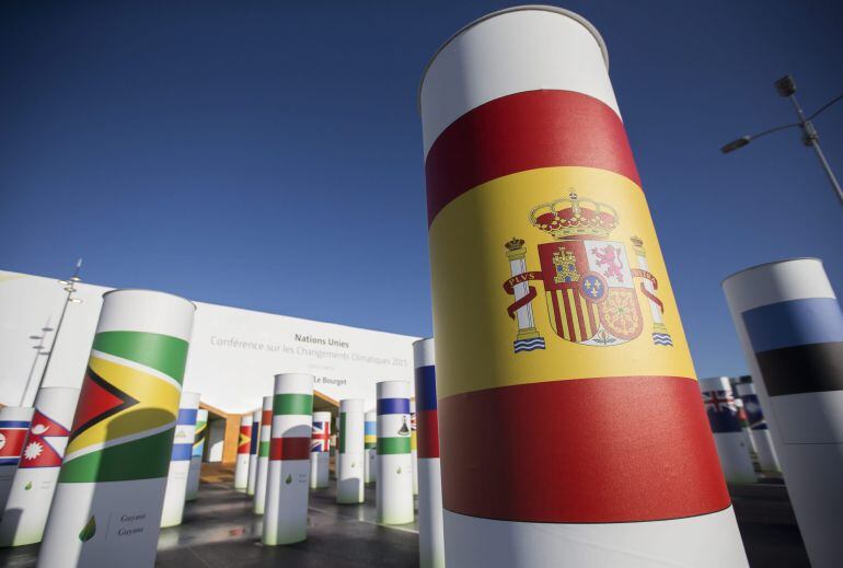 La bandera española adorna una de las columnas de la entrada al recinto donde se celebrará la Cumbre Mundial de Cambio Climático COP21.