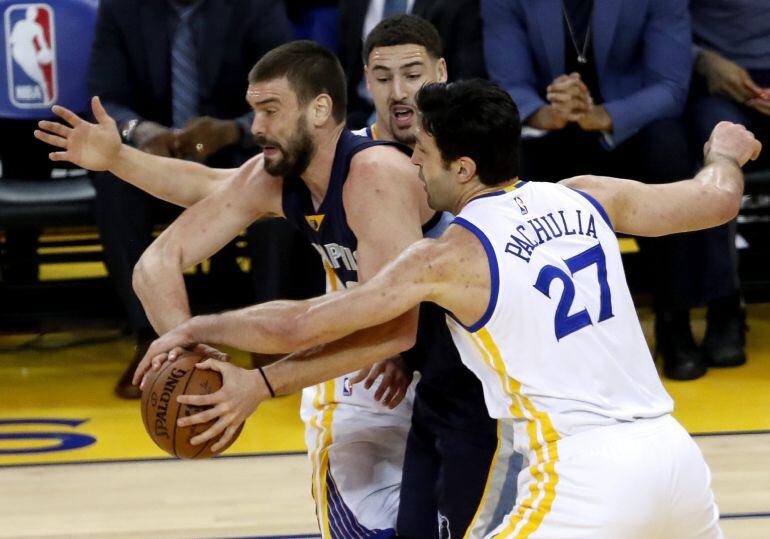 Pachulia pugna con Marc Gasol con el apoyo de Klay Thompson