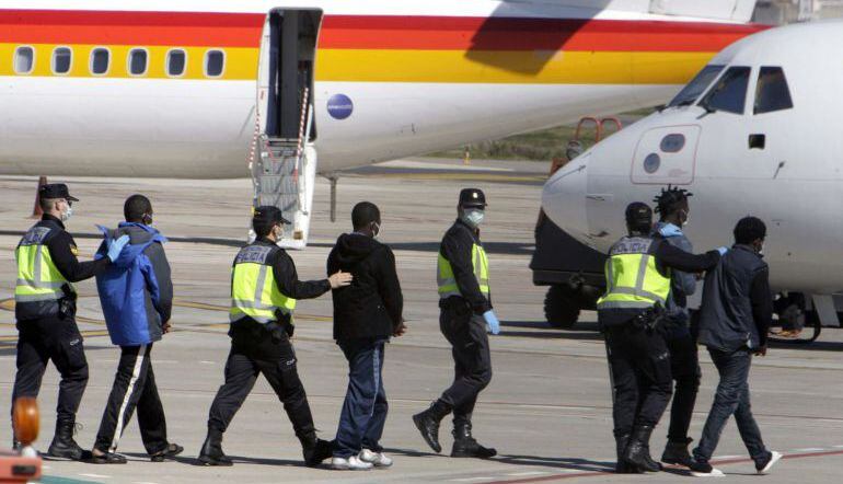 Agentes de la Policía Nacional trasladan hasta el avión a un grupo de inmigrantes (imagen de archivo).