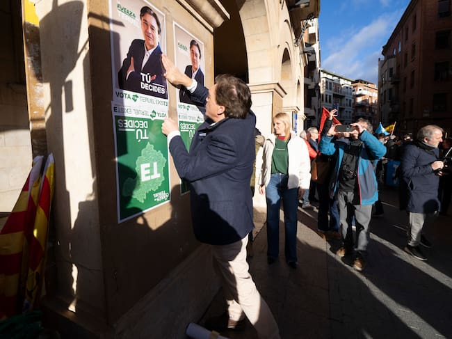 TERUEL, 23/01/2026.- Tradicional pegada de carteles electorales de los partidos políticos, este viernes en la plaza San Juan de Teruel. En la imagen, Tomas Guitarte, candidato ala presidencia del gobierno de Aragon por Teruel Existe. EFE/Antonio García