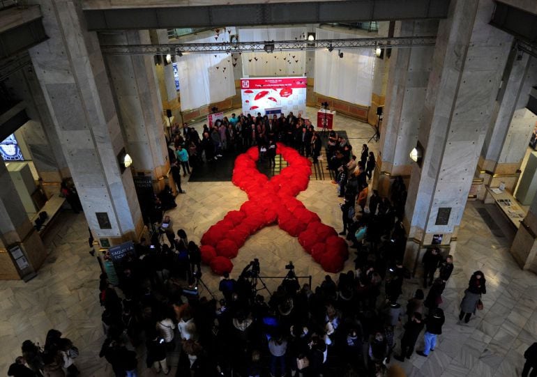 Un lazo de paraguas rojos se ha formado en el Palacio de Cibeles organizado por Madrid Salud con motivo del Día Mundial del Sida.