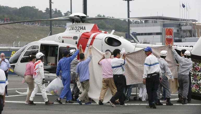 Personal sanitario de Motegi atiende al piloto Alex de Angelis.
