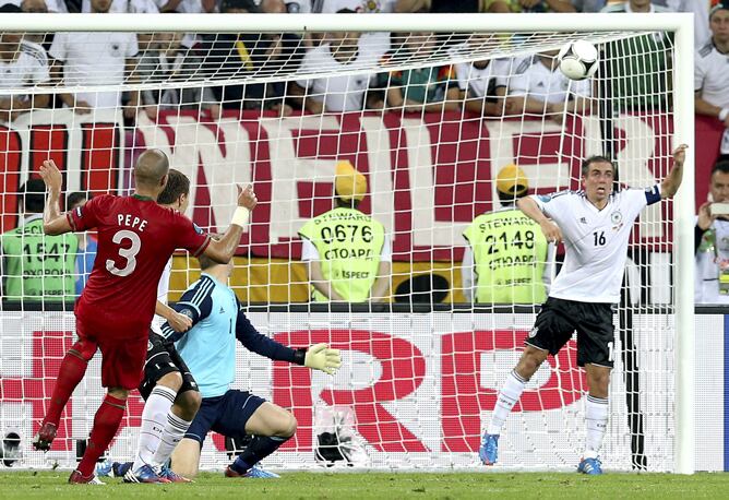 El jugador de la selección portuguesa Pepe dispara al larguero ante la presencia del internacional alemán Philipp Lahm durante el partido de la Eurocopa 2012 correspondiente al Grupo B entre las selecciones de Portugal y Alemania, en Lviv, Ucrania, el sáb