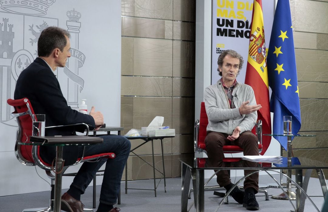 El ministro de Ciencia e Innovación, Pedro Duque, escucha la intervención del director del Centro de Coordinación de Alertas y Emergencias Sanitarias, Fernando Simón, en el encuentro #LaInfanciaPregunta, en Madrid.