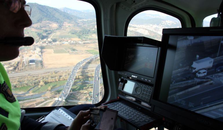 Una agent de la Divisó de Trànsit dels Mossos controlant la càmera de l'helicòpter del SCT 