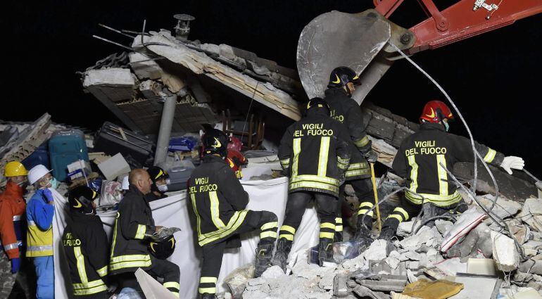 Los bomberos tratan de recuperar un cuerpo entre los escombros en la localidad de Amatrice.