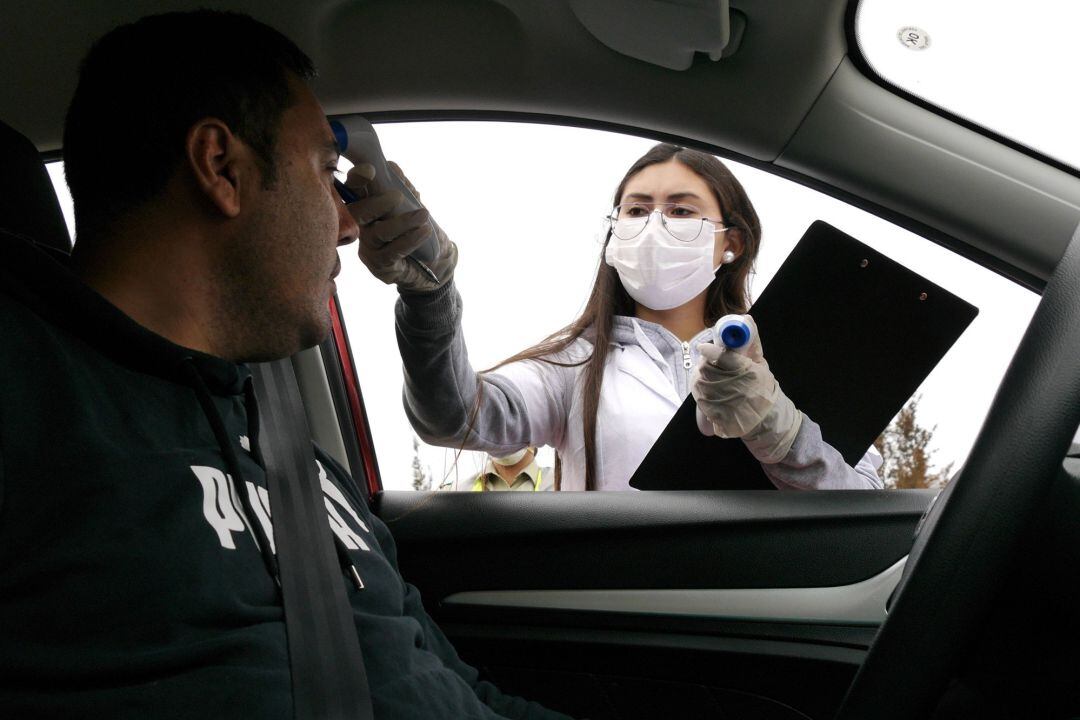 En la imagen, personal sanitario toma la fiebre a un conductor