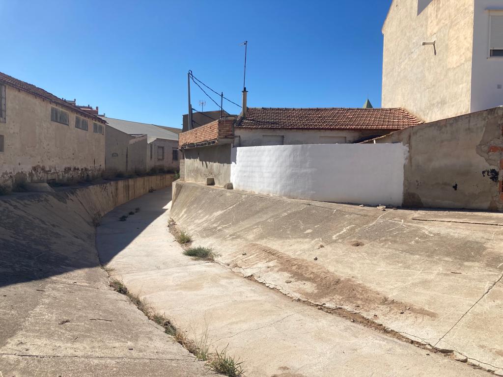 El muro pintado en blanco es la vivienda de Antonio, el vecino fallecido en Javalí Viejo por la riada. Los vecinos piden que se levante un muro que proteja las viviendas junto a la Rambla La Ventosa