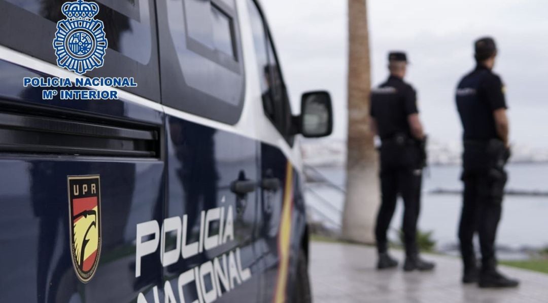 Agentes de la Policía Nacional junto a un coche patrulla.