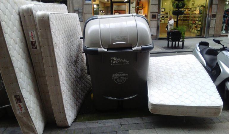 Colchones depositados junto a un contenedor de basura de Santander.