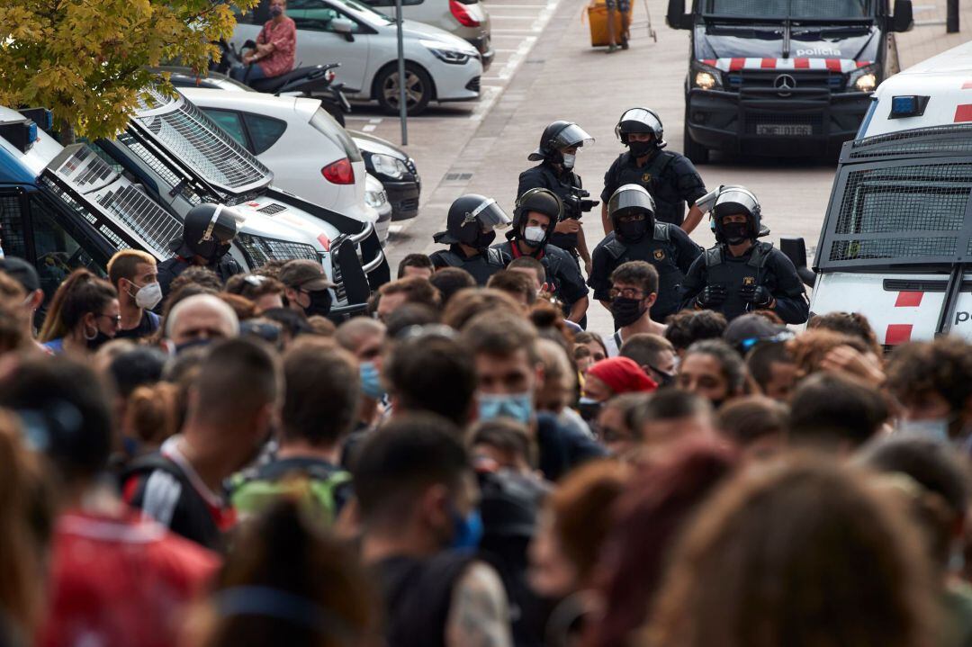 Agents dels Mossos d'Esquadra davant el més de mig centenar de persones que s'han concentrat per protestar pel desallotjament de l'habitatge