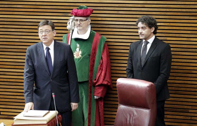 GRA040. VALENCIA, 28/06/2015.- El socialista Ximo Puig (i) promete el cargo como presidente de la Generalitat Valenciana ante el presidente de Las Cortes Valencianas, Francesc Colomer (d). Tres días después de su investidura, Puig ha puesto la mano sobre la Constitución, el Estatuto de Autonomía y Els Furs, y ha pronunciado en valenciano, como dispone el reglamento parlamentario, la fórmula establecida para asumir el cargo. EFE/Manuel Bruque
