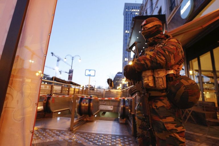 Policías y soldados vigilan junto al acceso de la estación de metro Porte de Namur en Bruselas