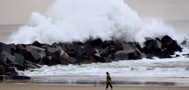 GRA023. SAN SEBASTIAN, 22/1/2015.- Un hombre observa como rompe una ola en el espigón de La Zurriola de San Sebastián, donde hoy se deja notar aún el temporal que sufre la ciudad en los últimos días. EFE/Javier Etxezarreta
