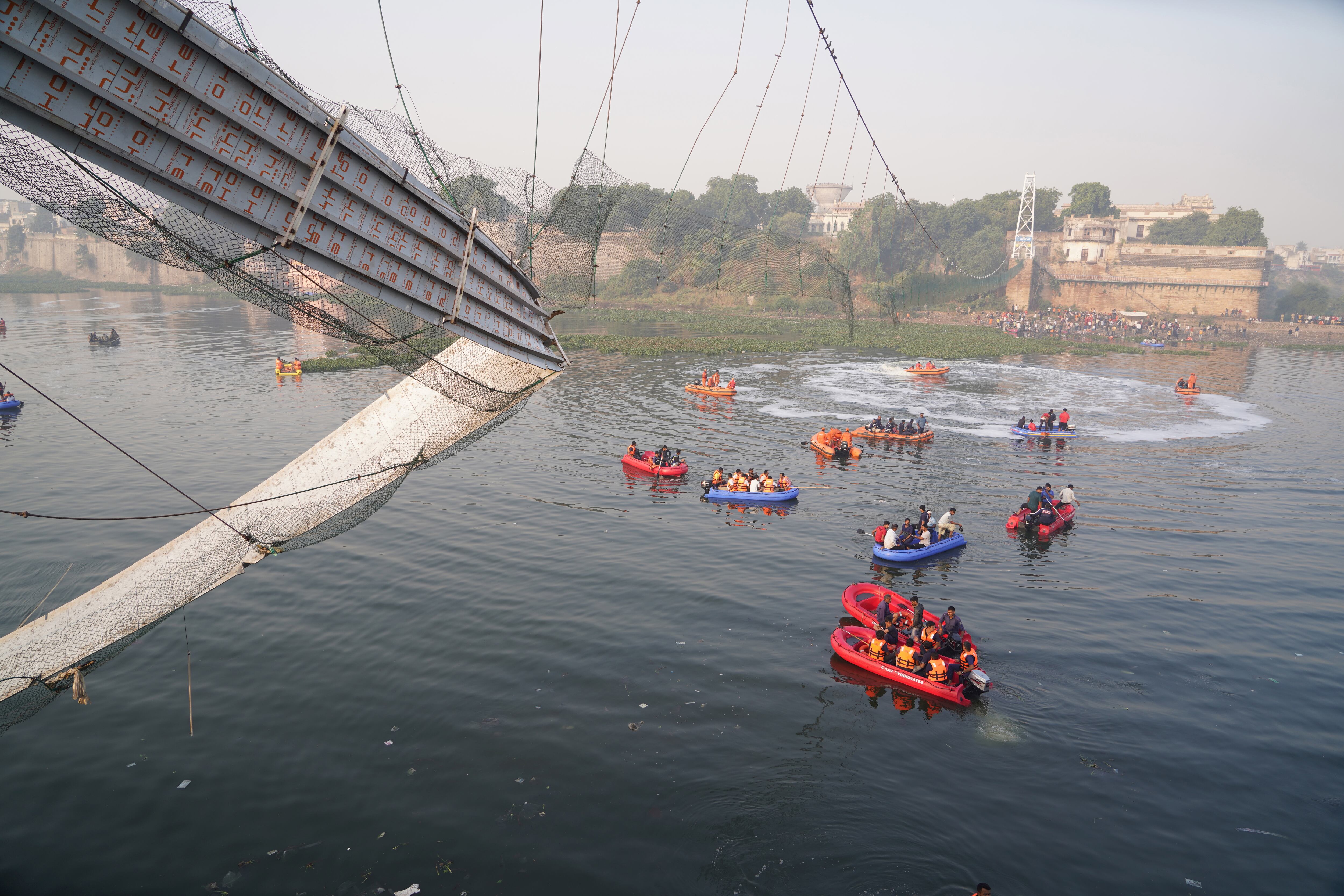 Morbi (India), 31/10/2022.- National Disaster Response Force (NDRF) police and miltary personnel work at the site after a 100-year-old suspension bridge collapsed in Morbi, Gujarat, India, 31 October 2022. According to the police officials in Gujarat, at least 130 people have been reported dead in the incident and police, military and disaster response teams were deployed for the continuing rescue operations. EFE/EPA/SIDDHARAJ SOLANKI
