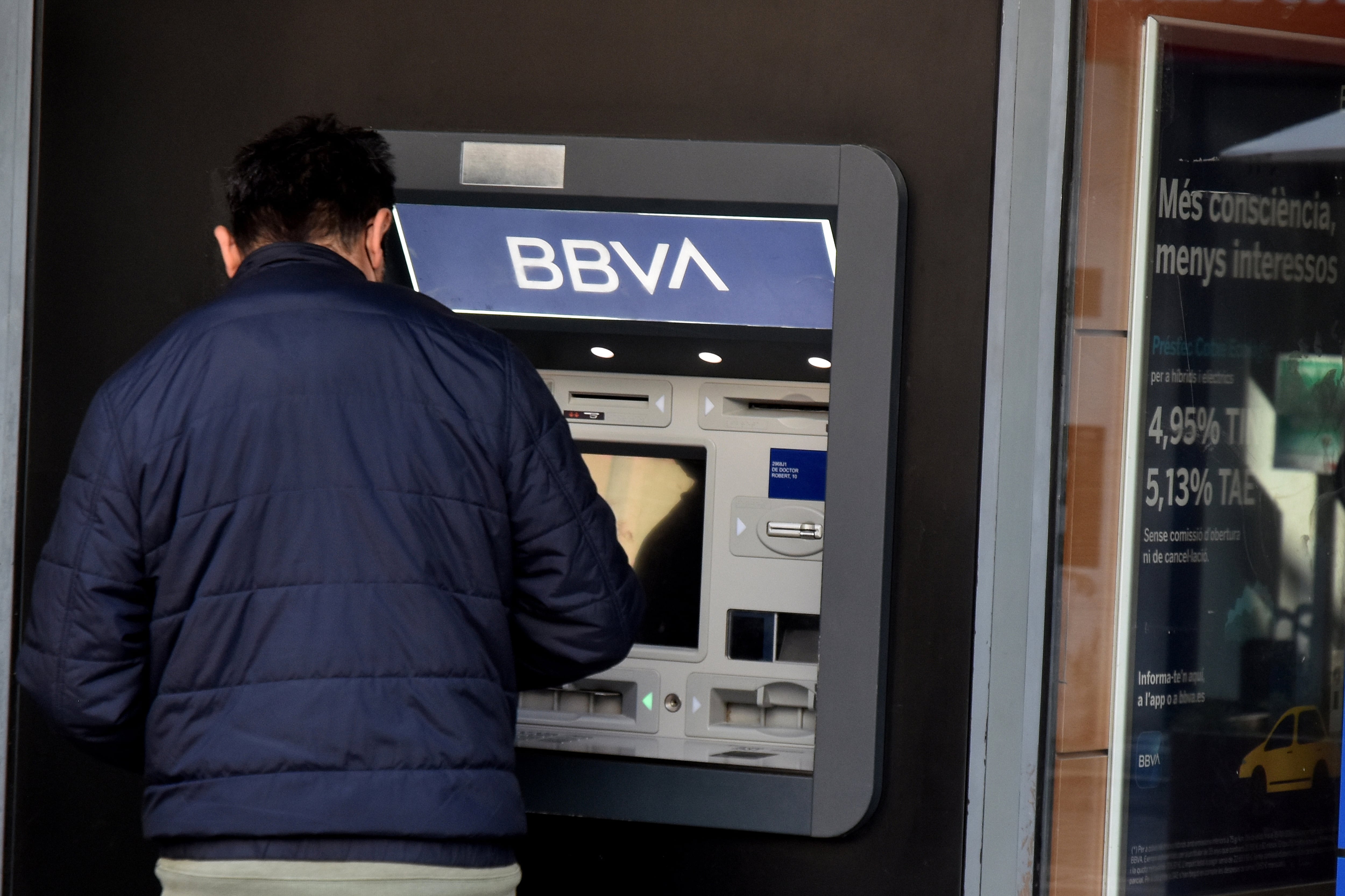 Una persona sacando dinero de un cajero del BBVA.