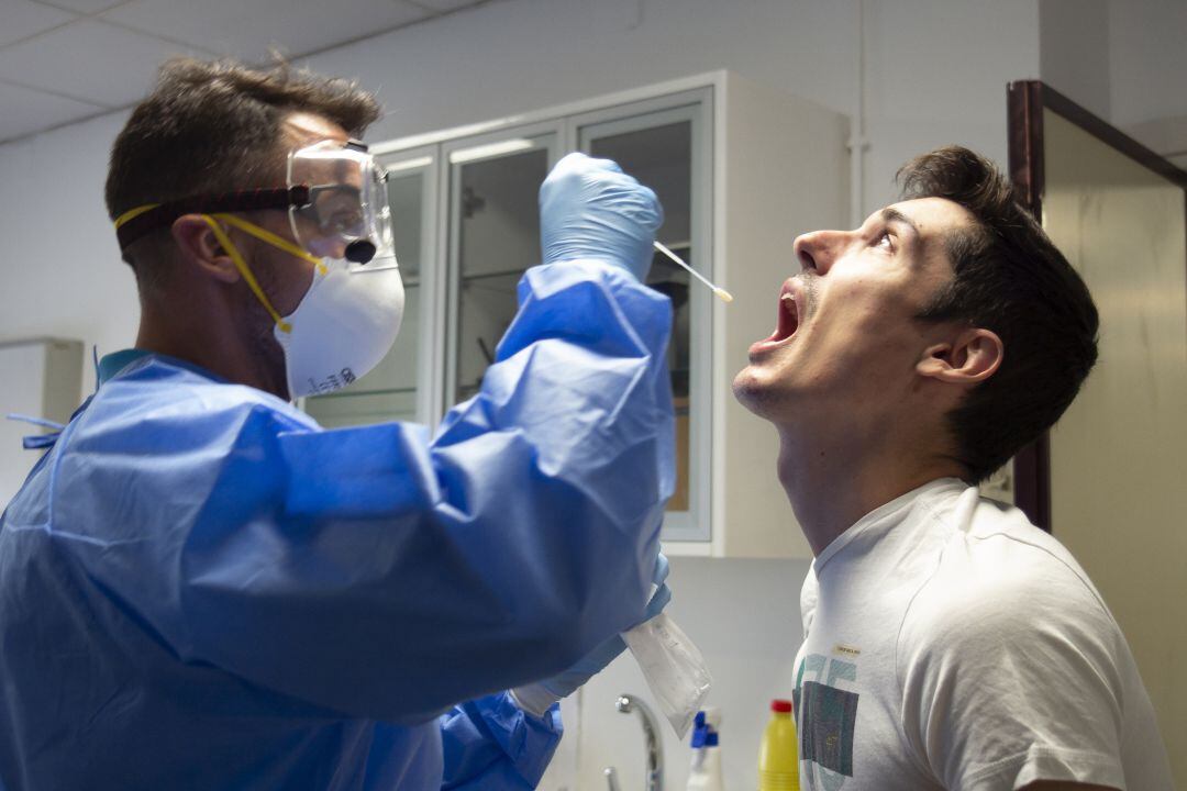 Un trabajador sanitario realizando uan prueba PCR. 