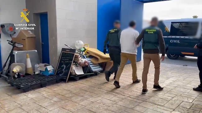 Los agentes acompañan a uno de los detenidos