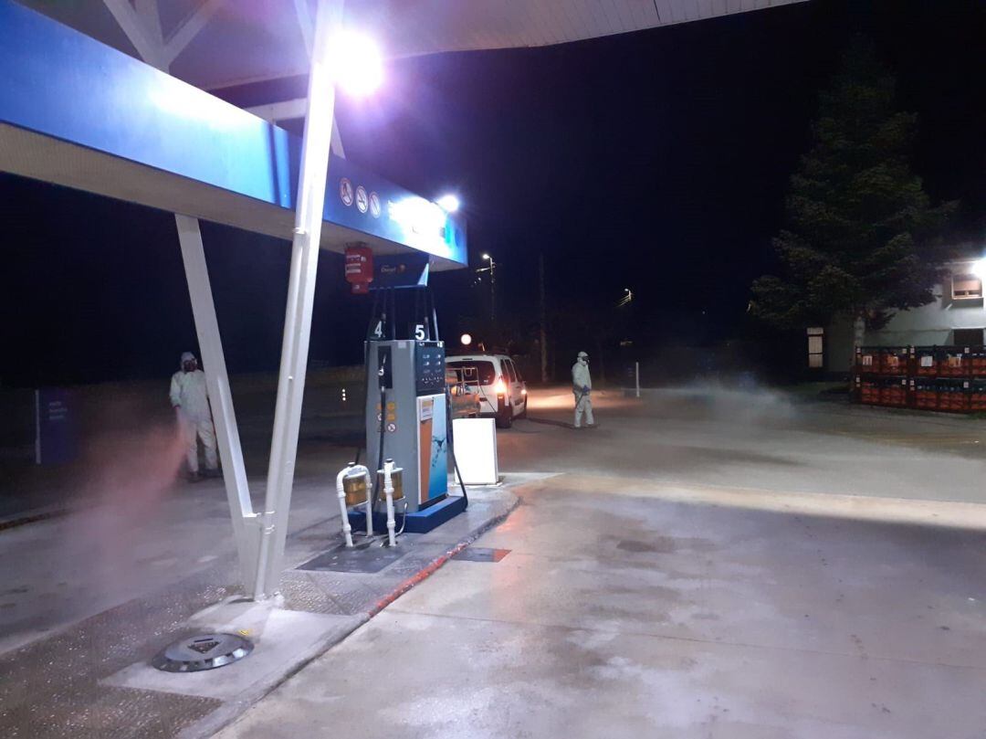 Efectivos del dispositivo regional de desinfección en una gasolinera