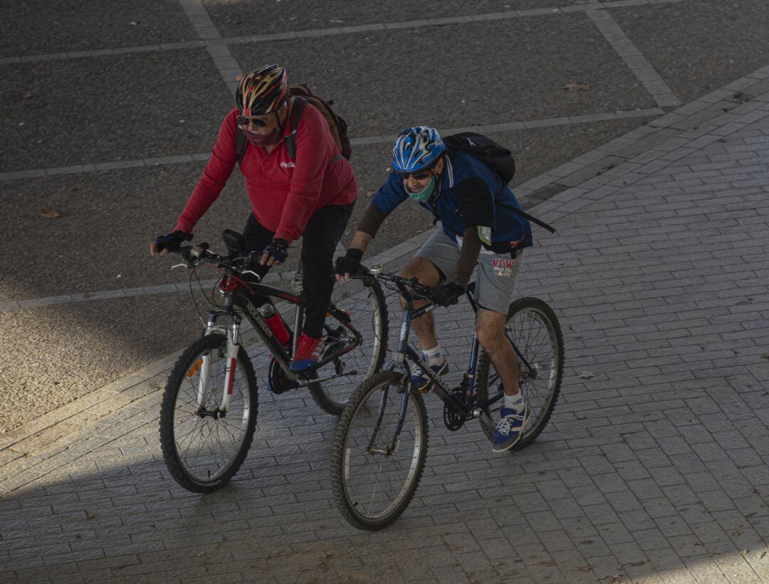 Dos ciclistas con mascarilla. 