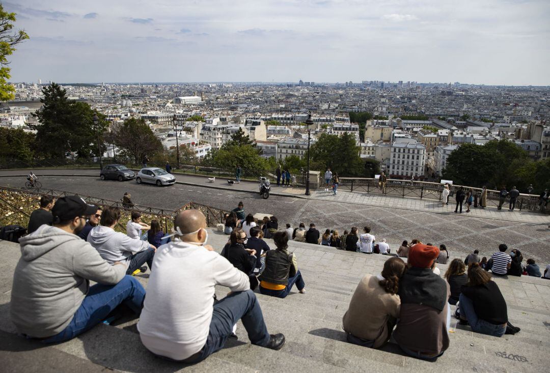 Parisinos disfrutan del sol en las escalinatas del Sacre Coeur.