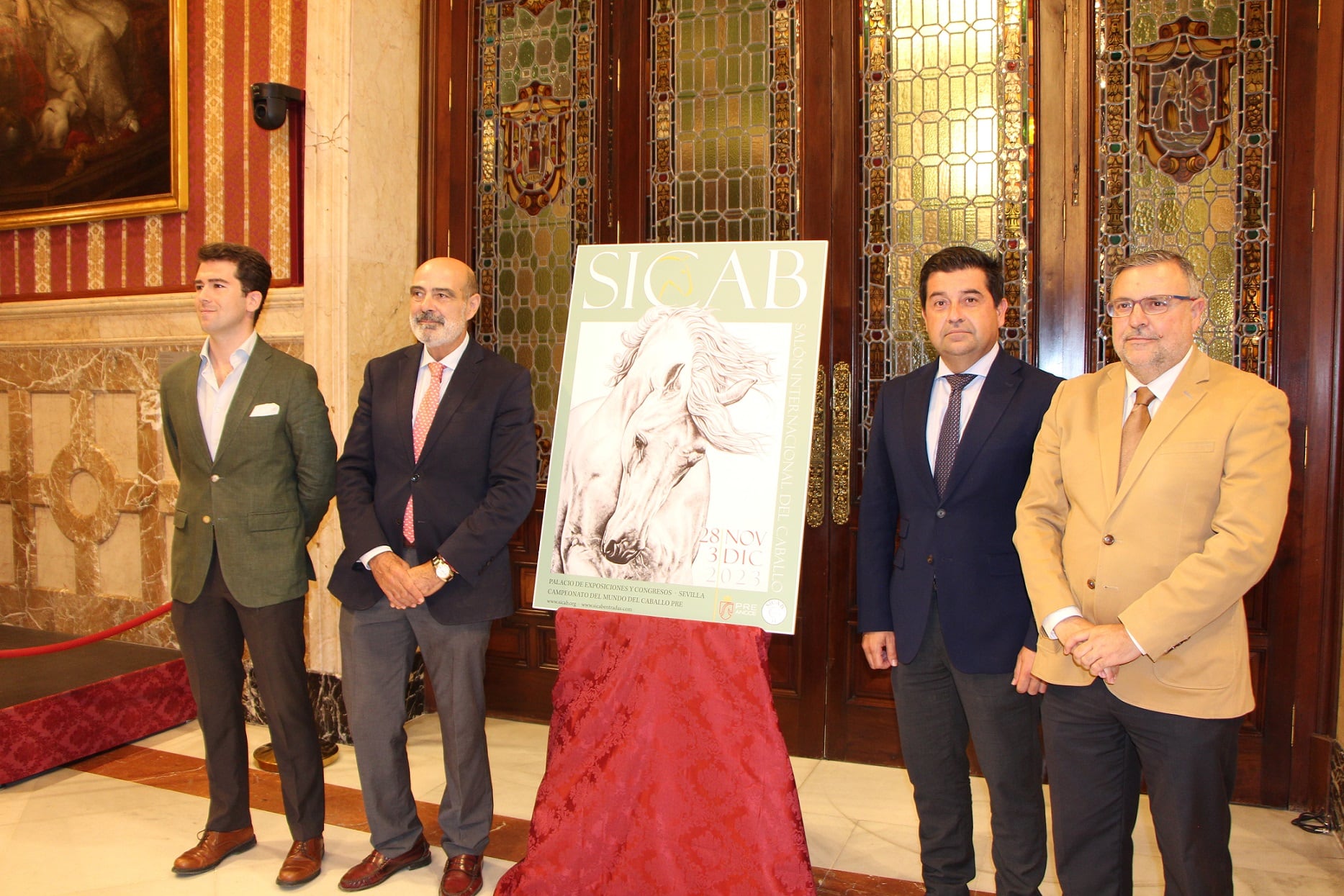 De izquierda a derecha junto al cartel anunciador del SICAB 2023, el pintor Francisco Gil, José Juan Morales, presidente de ANCCE; y Carlos García Lara y Diego ramos en representación del Área de Fiestas Mayores del Ayuntamiento de Sevilla