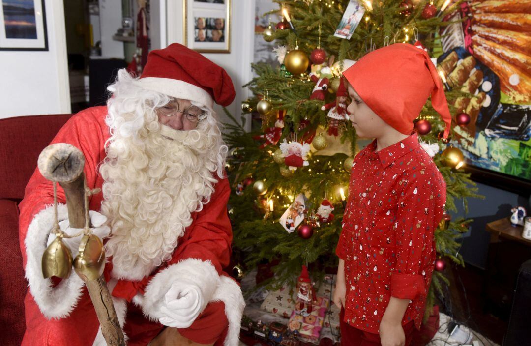 Papa Noel visita a una familia por Navidad. 