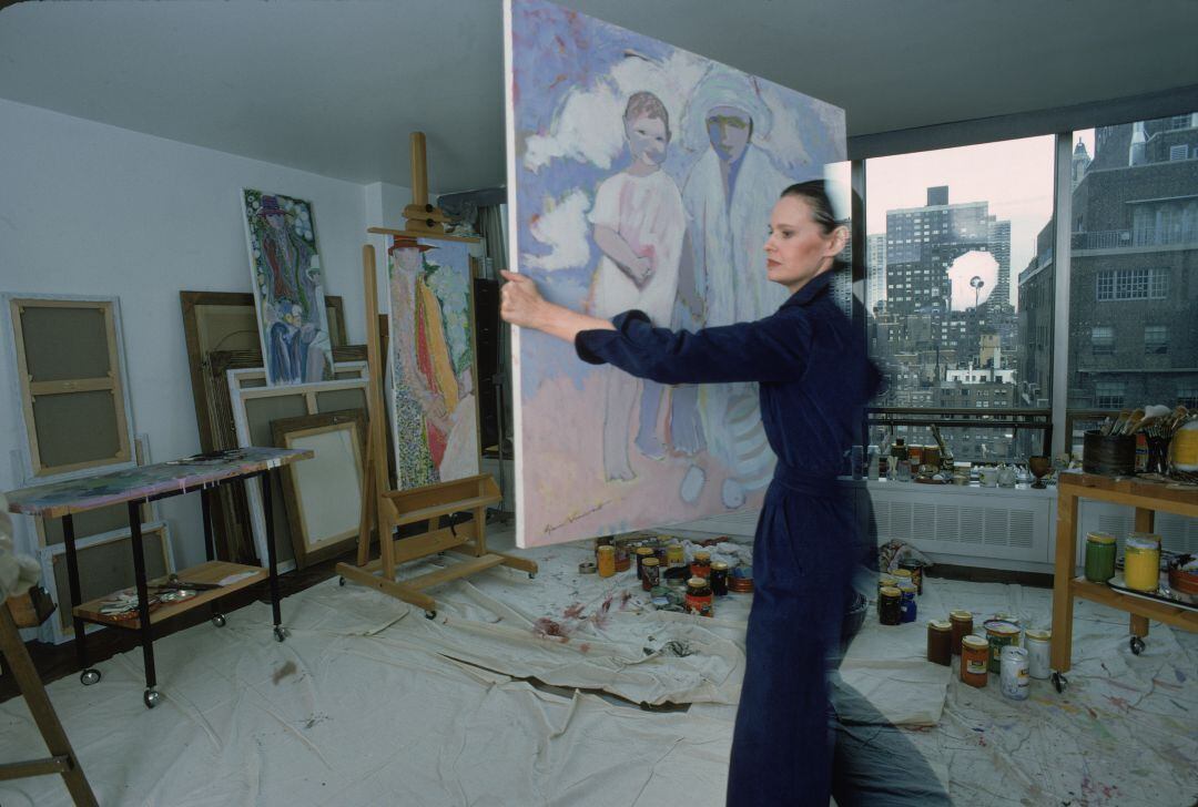 Gloria Vanderbilt lleva una pintura en su estudio en su casa en Nueva York