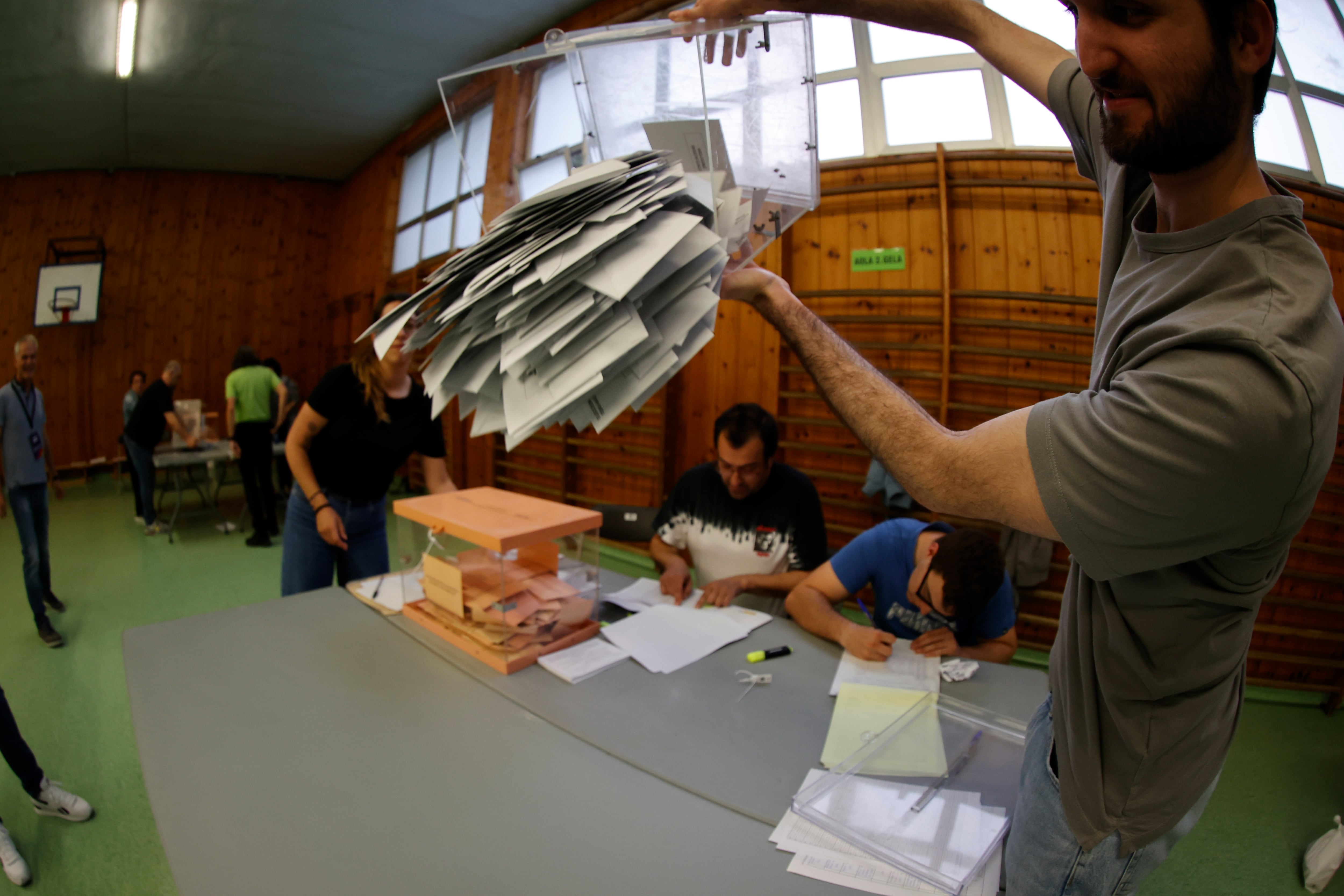 Los miembros de una mesa electoral proceden a la apertura de las urnas para el recuento de votos tras el cierre de los colegios.