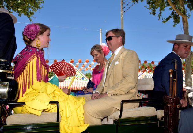 Los Reyes de Holanda, Máximo y Guillermo, y su hija Amalia, durante un paseo en coche de caballos este viernes en la Feria de Sevilla.