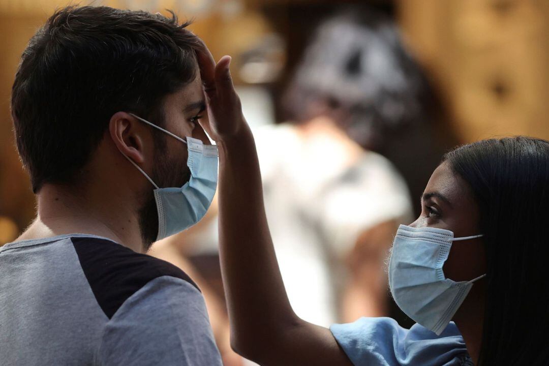 Una pareja con mascarillas en Madrid este sábado durante la ola de calor
