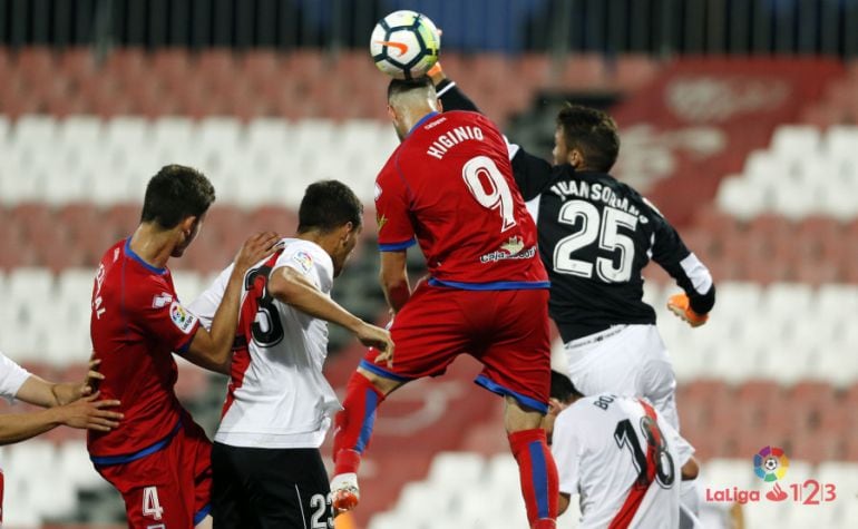 Soriano, portero hispalense, despeja en presencia de Higinio y Elgezabal.