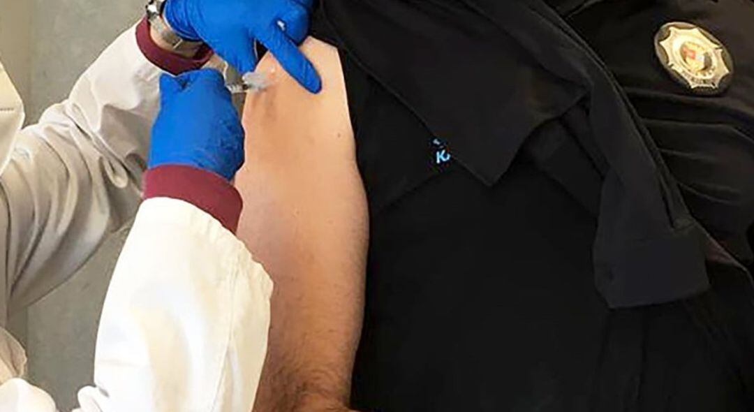 Vacunando a un policía de la localidad