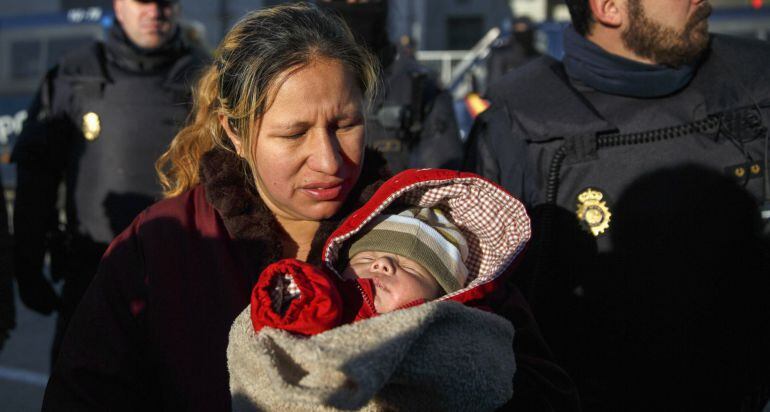 Cecilia Paredes, 43, holds her one-month-old son Dilan in front of riot policemen after her family was evicted from their apartment in Madrid, January 23, 2015. Paredes, her husband Wilson Ruilova, 35, and their sons Andres, 16, Miguel, 7 and Dilan have been living in the apartment that belongs to the Municipal Housing and Land Company (EMVS) for about four years. The couple are currently jobless and living on a shared total of 341 Euros ($382) in monthly subsidy. Unable to cope with the rent, Parades and her husband stopped paying it about two years ago. Their apartment was eventually sold by the EMVS to a private investment company. REUTERS/Andrea Comas (SPAIN - Tags: BUSINESS POLITICS EMPLOYMENT SOCIETY POVERTY REAL ESTATE)