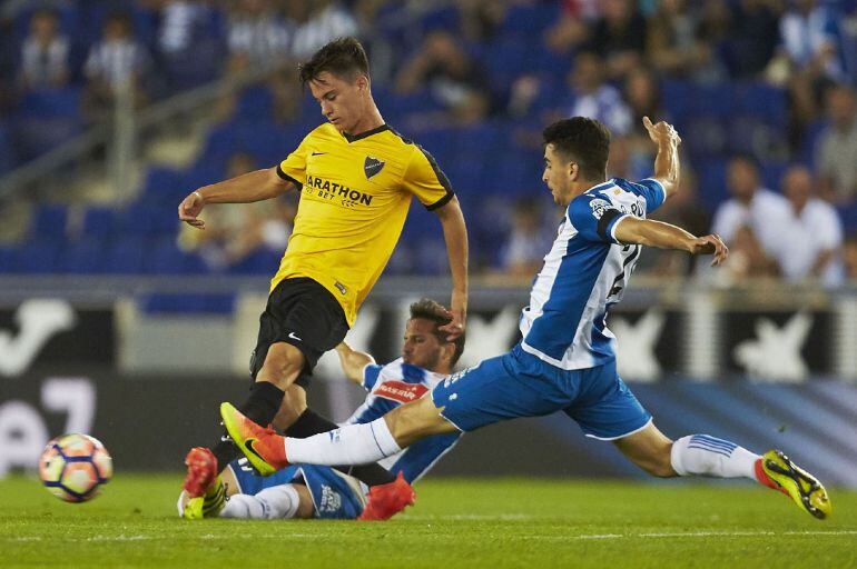 Juanpi intenta pasar el balón ante los españolistas Roca y Piatti