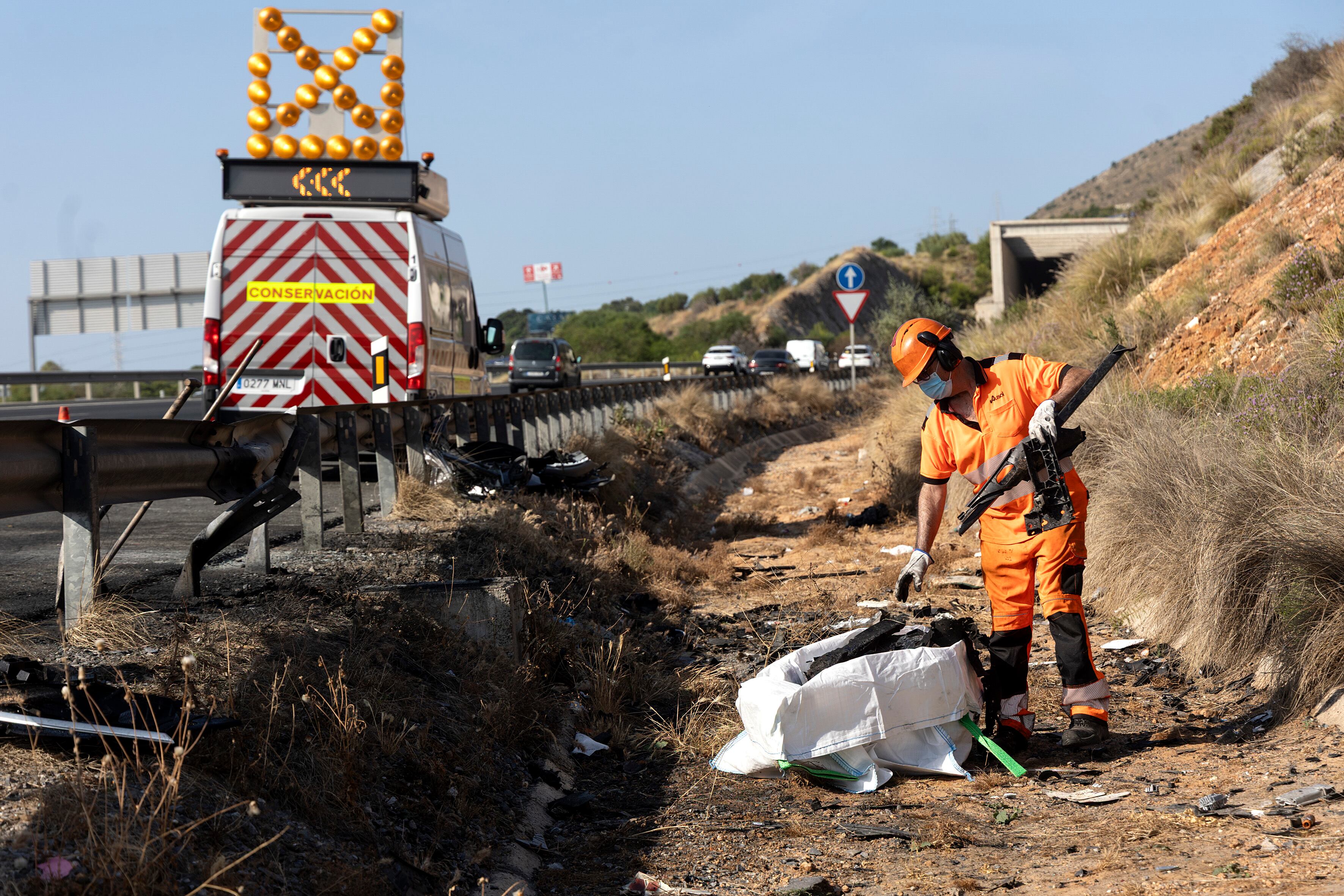 GRAFAND9082. MÁLAGA, 05/06/2025.- Un operario retira en la A-7, dirección Torremolinos (Málaga), restos de los dos coches que han colisionado esta madrugada tras una persecución por un robo en una farmacia ubicada en Málaga capital, por lo que han fallecido cuatro personas, uno de ellos un agente de la Policía Nacional, de 48 años y con dos hijos cuando volvía en su coche a su domicilio tras trabajar en el turno de noche. EFE/Daniel Pérez
