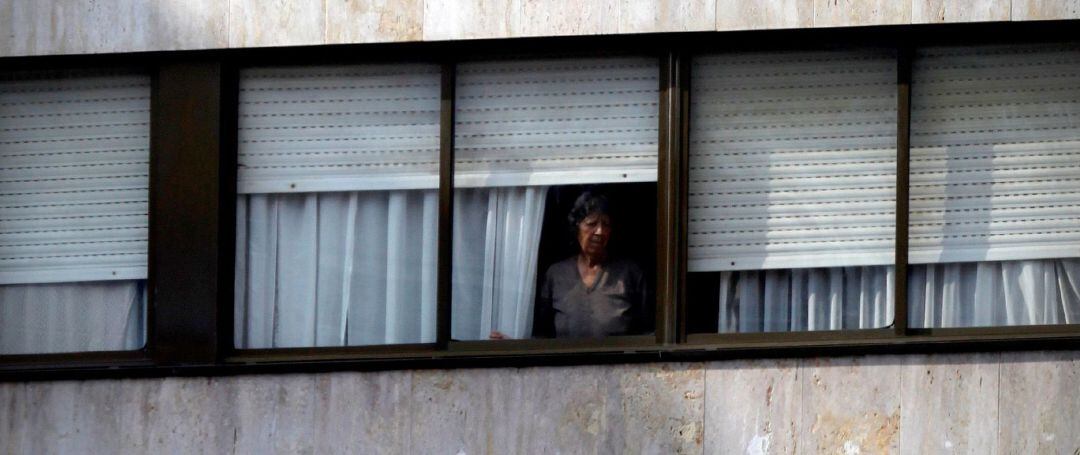 Una vecina de A Coruña mira por su ventana en medio del confinamiento