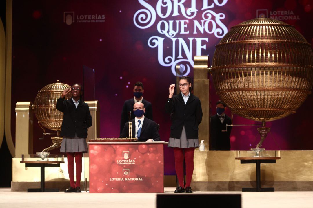 Dos de las niñas de la residencia de San Ildefonso, cantan uno de los quintos premios de la Lotería de Navidad, 