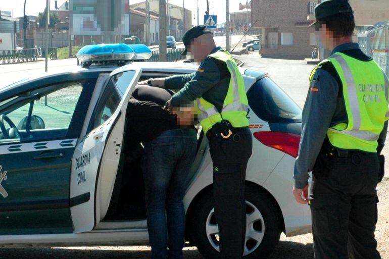 Agentes del Instituto Armado introducen a uno de los detenidos en el coche
