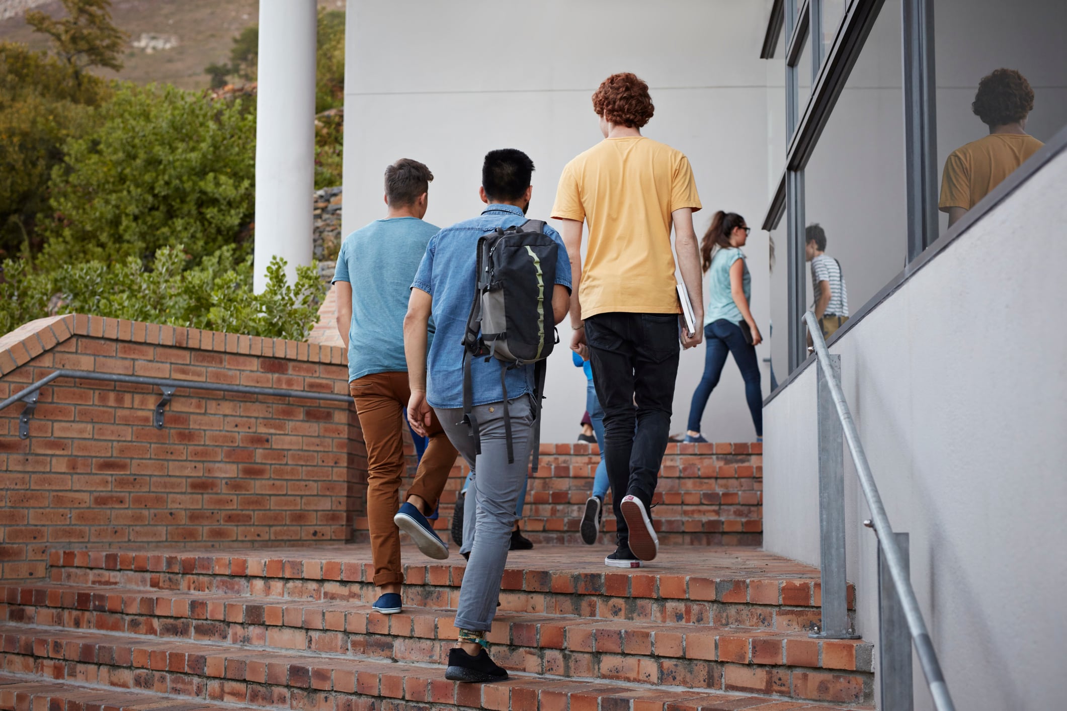 Estudiantes suben unas escaleras para entrar a un centro educativo