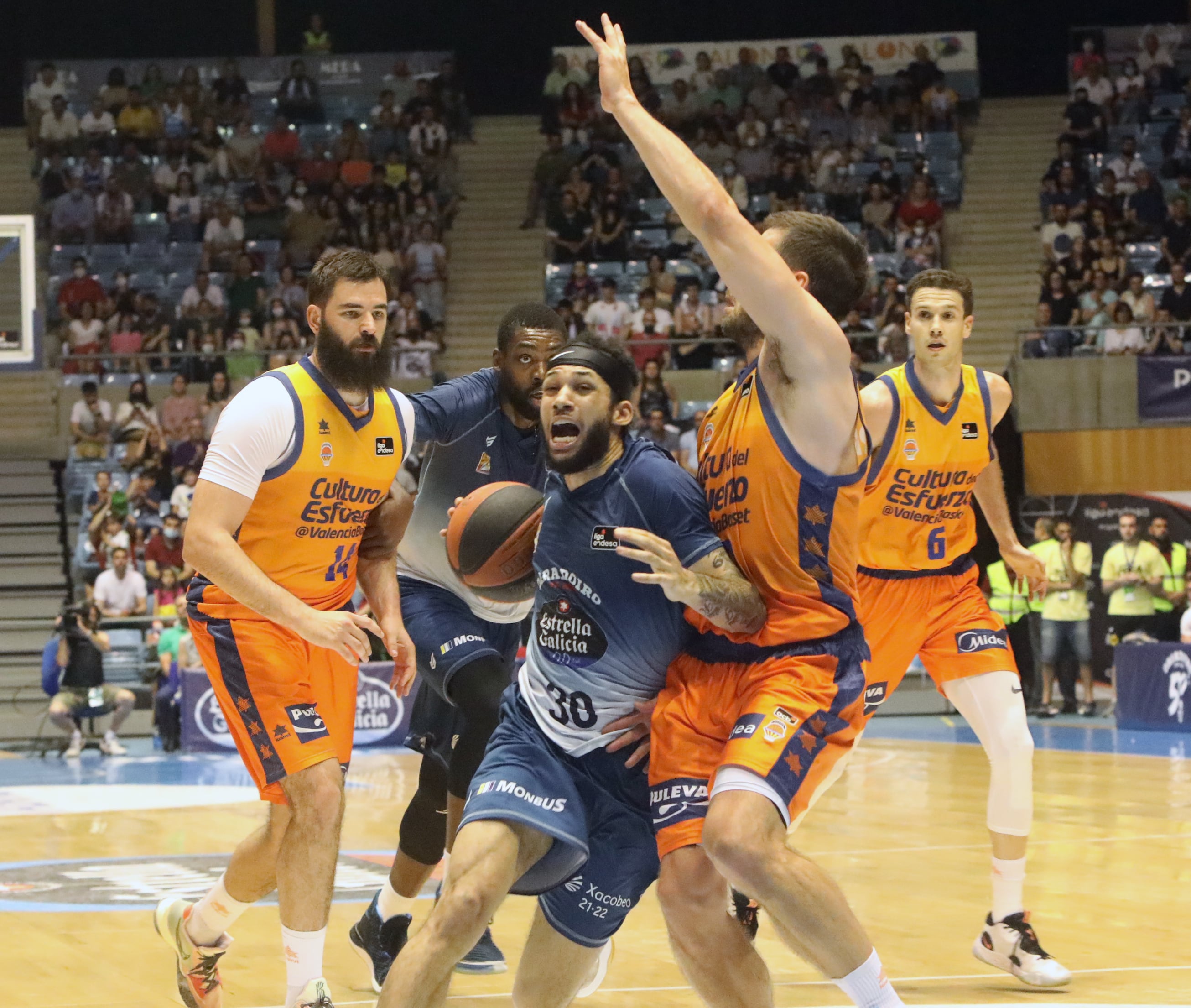 Santiago de Compostela.14/05/2022. El jugador del Obradoiro, Kassius Robertson (c) busca la canasta ante los jugadores del Valencia, Bojan Dubljevic (i) y Sam Van Rossom (d) durante el encuento de la Liga ACB celebrado esta noche en el Multiusos de Sar de Santiago de Compostela. EFE. Xoán Rey.
