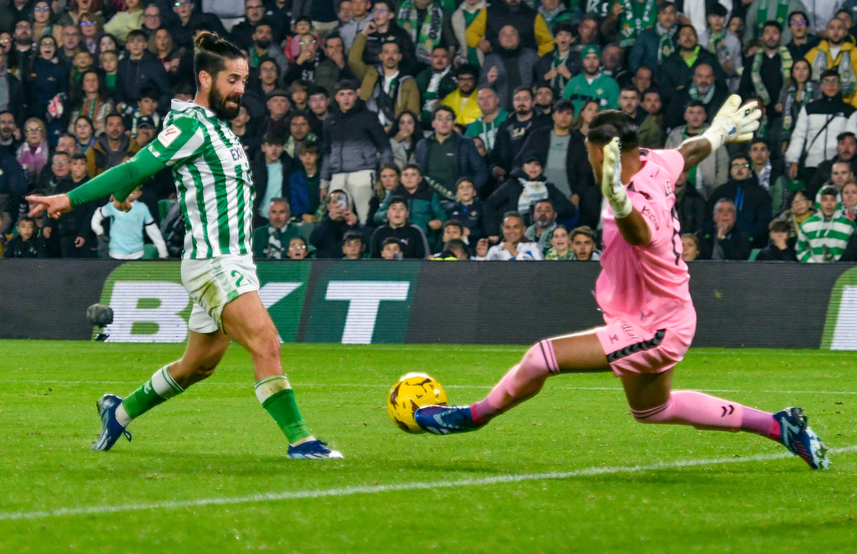 SEVILLA. 01/02/2023. -El centrocampista del Real Betis Isco (i) ante el guardameta de la UD Las Palmas Álvaro Valles durante el partido de la jornada 14 de la Liga EA Sports que se ha disputado esta noche en el estadio Benito Villamarín de Sevilla. EFE/ Raúl Caro.
