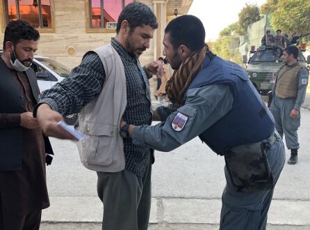 Un votante es cacheado en la entrada de un colegio electoral.