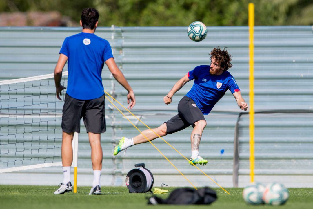 El media punta del Athletic Club, Iker Muniain (d) golpea un balón durante el entrenamiento que ha celebrado el equipo este jueves en sus instalaciones de Lezama (Bizkaia).