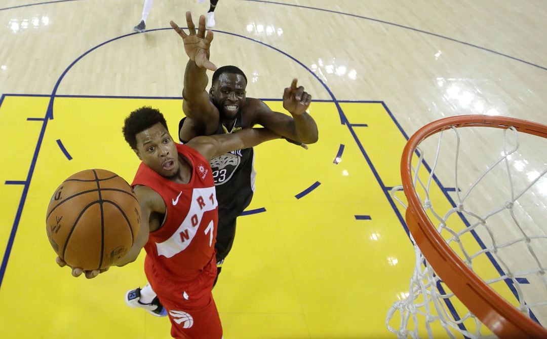 Kyle Lowry intenta entrar hacia canasta seguido por Draymond Green en uno de los encuentros de las Finales de la NBA