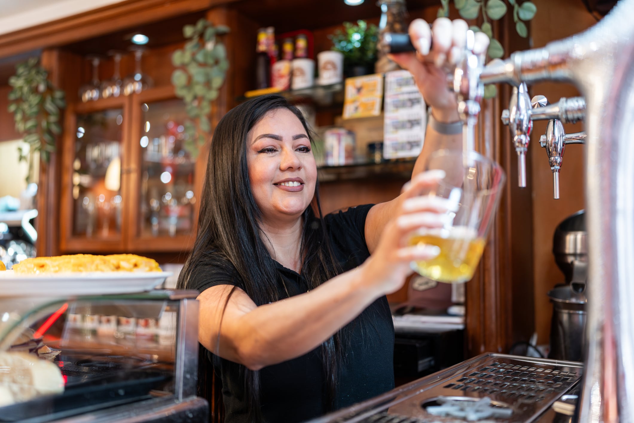 Una camarera sirve una caña en un bar de Bilbao.